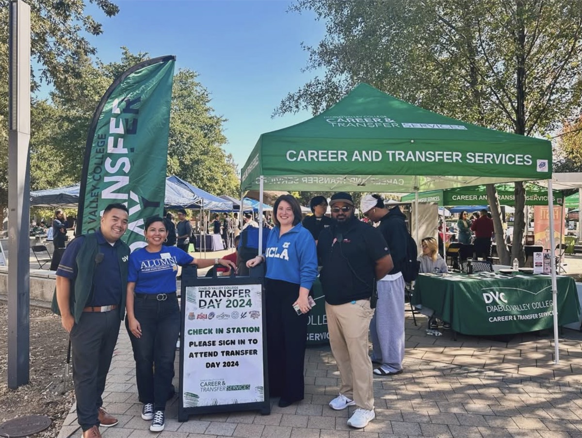 Rebecca Barrett in a UCLA sweatshirt with staff and students at Diablo Valley College’s Transfer Day check-in station
