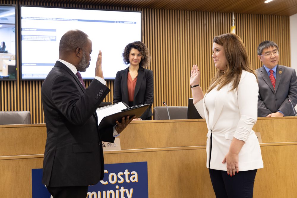 Rebecca Barrett raises her right hand as she is sworn in to the Governing Board