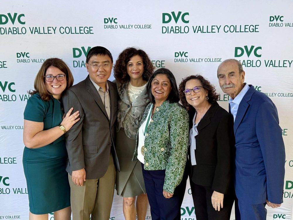 Rebecca with colleagues in front of a Diablo Valley College backdrop