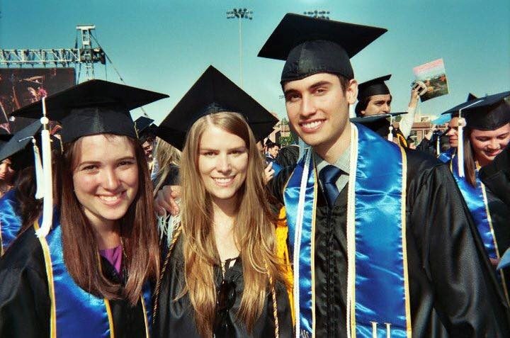 Rebecca with fellow UCLA graduates in caps, gowns, and blue stoles at commencement